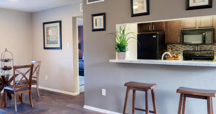 Open dining area with a view of the modern kitchen in a Carrollton, TX apartment.