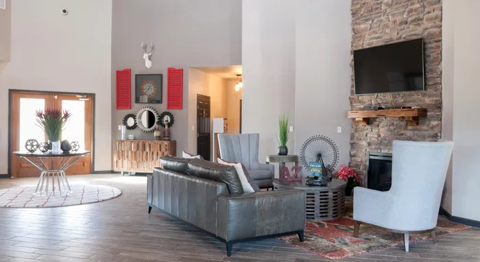 Spacious clubhouse lounge in a Carrollton, TX apartment complex with a fireplace and modern seating.