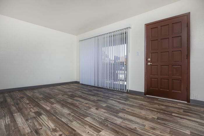 Spacious living room with large windows at Las Brisas Apartments in Albuquerque, NM.