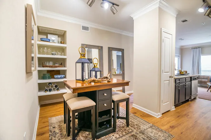 comfortable dining space with light walls, built-in shelves, and hardwood floors