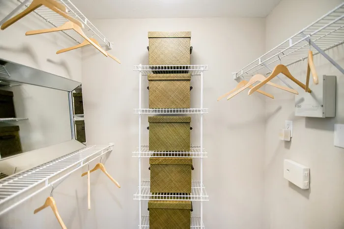 a walk in closet with built-in wire shelving