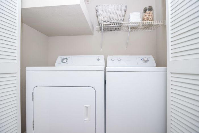 closet with a washer, dryer, and built-in shelving