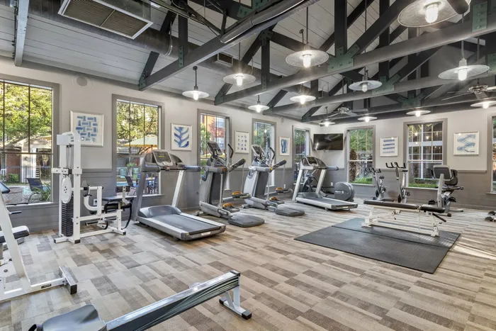 fitness center filled with bright lighting, exercise equipment, and weights
