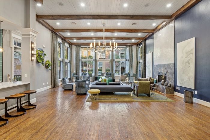 stunning clubhouse with seating, hardwood floors, large windows, and a fireplace