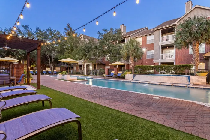 view of sparkling swimming pool, poolside lounge seating, and a clean manicured lawn