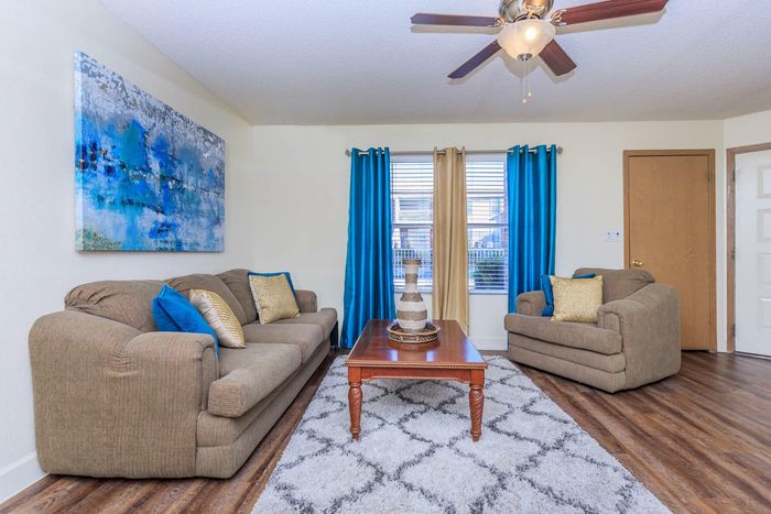 a spacious living room with a lot of natural light at Whispering Pines Apartments in El Paso, TX