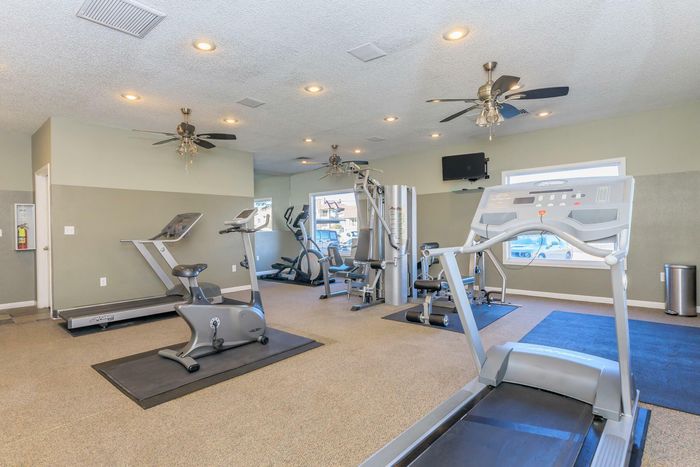 Modern fitness center with state-of-the-art equipment and ample space for workouts at Whispering Pines Apartments in El Paso, TX.