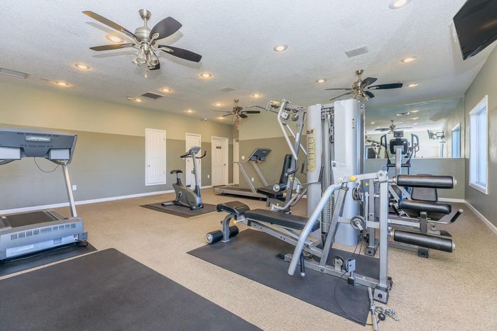 Fully equipped fitness center with modern machines at Whispering Pines Apartments in El Paso, TX.
