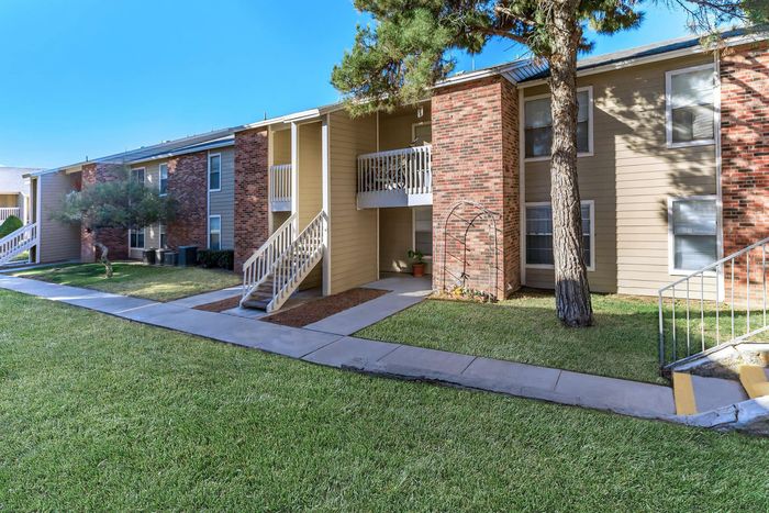 Whispering Pines Apartments' landscaped green lawns and exterior with private balconies in El Paso, TX.