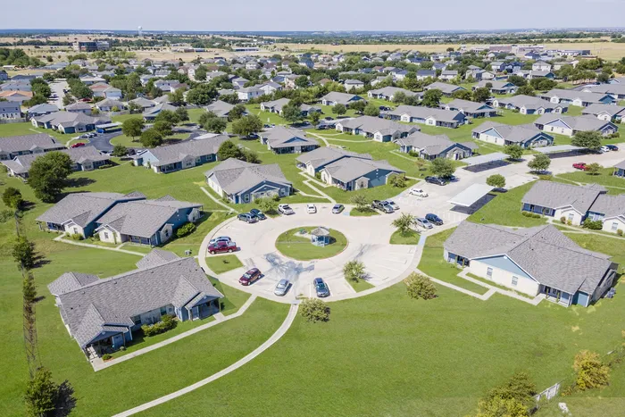 Aerial view of Crescent Village in Elgin, TX showcasing homes, greenery, and layout