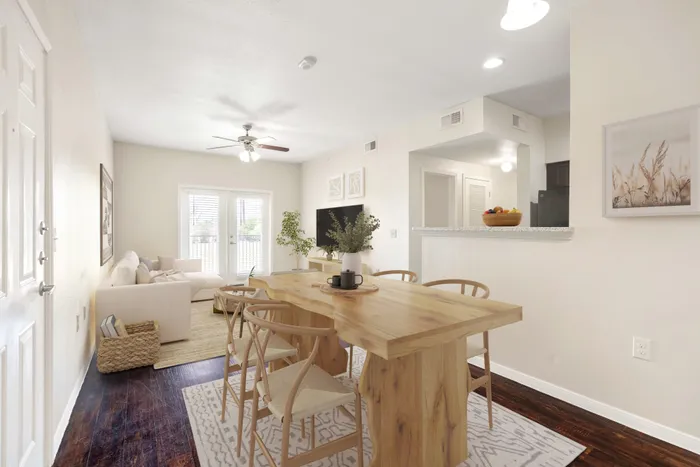 Staged living and dining area with modern decor and French doors leading to a balcony in Seguin, TX.
