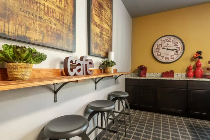 Community cafe space in a Carrollton, TX apartment complex with seating and decor.