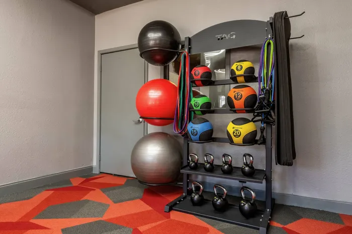 Fully equipped fitness room in a Carrollton, TX apartment complex with kettlebells and resistance bands.