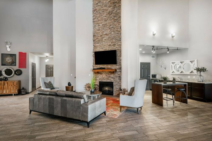 Spacious clubhouse lounge in a Carrollton, TX apartment complex with a fireplace and modern seating.