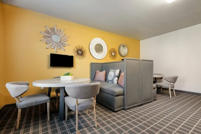 Shared workspace in Carrollton, TX apartment complex with private booths and modern decor.