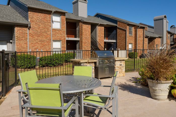 Outdoor grilling and dining area at a Carrollton, TX apartment community with modern amenities.