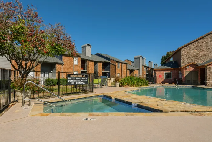 Outdoor pool and hot tub with spacious deck in a Carrollton, TX apartment community.