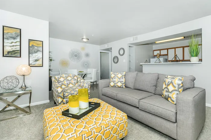 a living room with wall-to-wall carpets, a couch, chair, and other furniture