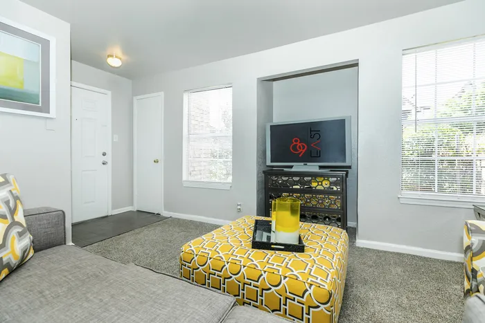 a wall with a cut out space, filled with a tv atop a tv stand