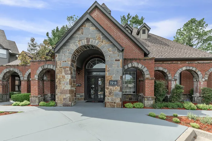 a building made of brick and stone with a large archway standing over the entryway