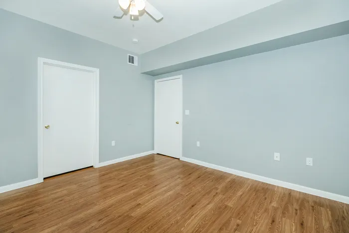 Spacious bedroom with plush carpeting, a large window, and a cozy bed at Portside Villas, Ingleside, TX