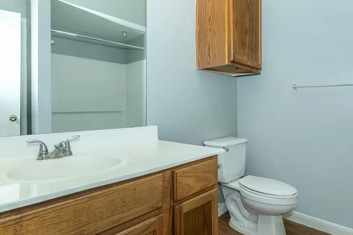 Modern bathroom with a sleek vanity, large mirror, and elegant lighting at Portside Villas, Ingleside, TX.