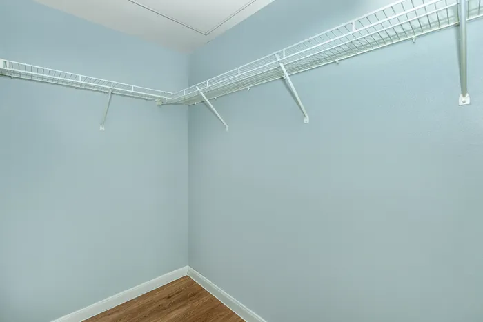 Spacious walk-in closet with built-in shelving and ample storage space at Portside Villas, Ingleside, TX.