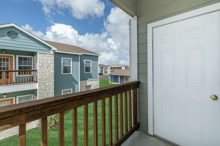 Private balcony with scenic views of lush landscaping at Portside Villas in Ingleside, TX.