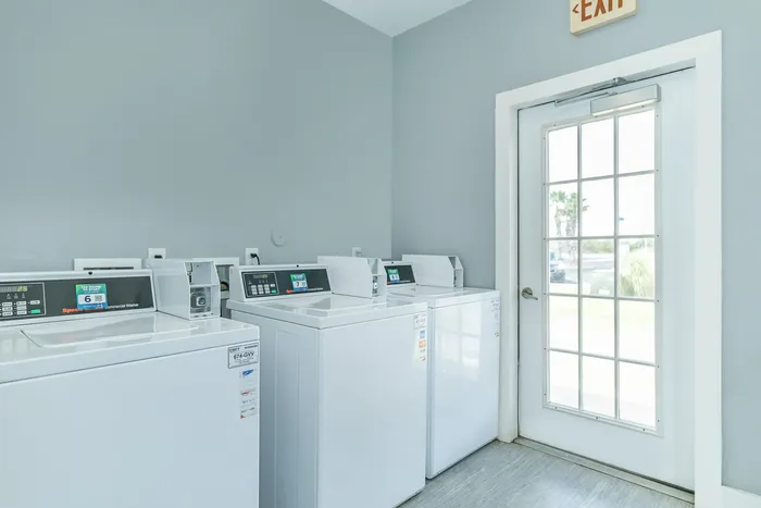 Modern onsite laundry center with energy-efficient machines at Portside Villas, Ingleside, TX.