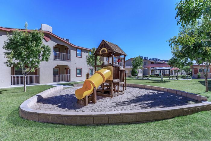 A vibrant playground with slides, swings, and climbing structures at Bella Vista Place, El Paso, TX