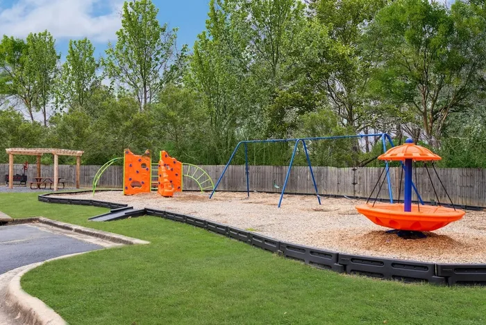Colorful playground with slides, climbing structures, and seating at Riverside at Rockwater, North Little Rock, AR