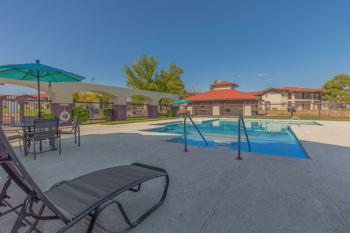 Outdoor pool with comfortable lounge chairs and shaded seating at Santa Teresa Terrace in Santa Teresa, NM.