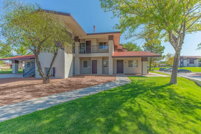 Two-story apartment buildings surrounded by green lawns and trees at Santa Teresa Terrace in Santa Teresa, NM.