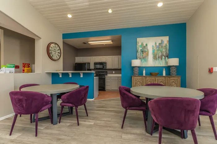 Dining area in the clubhouse with purple chairs and a modern kitchen backdrop at Santa Teresa Terrace in Santa Teresa, NM.