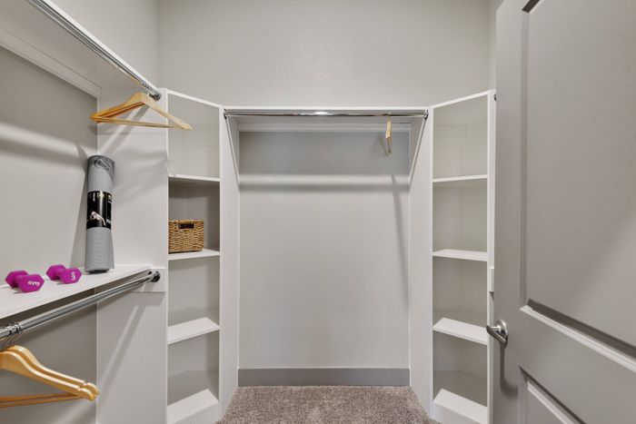 Elegant walk-in closet featuring built-in organizers and sleek design at Discovery Park, Denton, Texas.