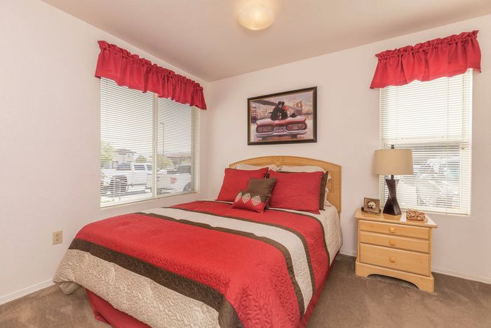 Bright bathroom with a single sink vanity, framed artwork, and red accents at Santa Teresa Terrace in Santa Teresa, NM.
