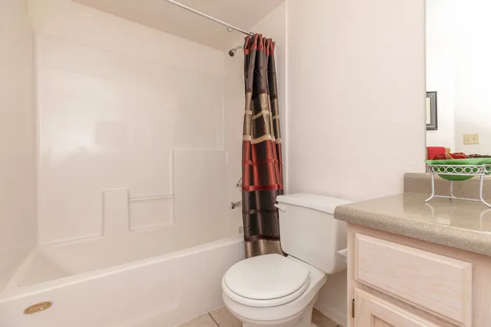 Bathroom with a bathtub, shower curtain, and vanity area at Santa Teresa Terrace in Santa Teresa, NM.