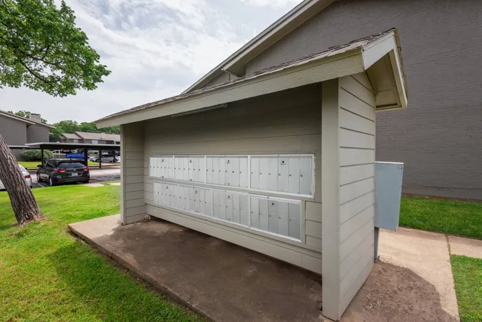 Modern mail center at Oak Park Apartments in Euless, TX, with individual mailboxes under a shaded roof.