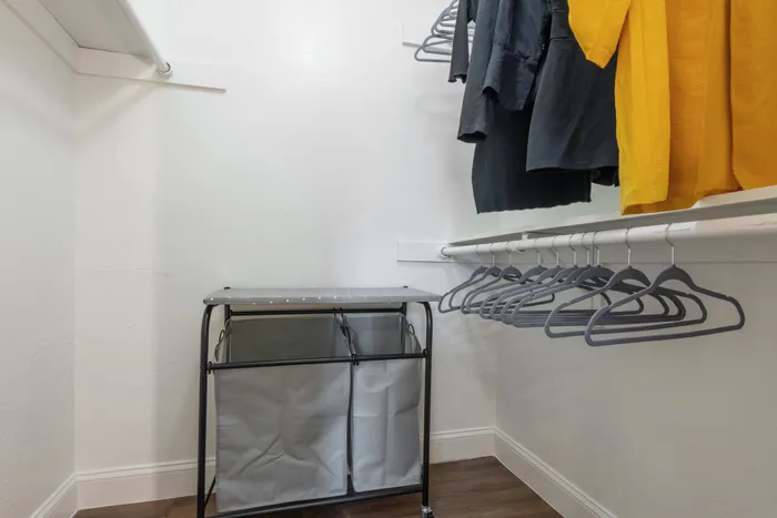 Spacious walk-in closet at Oak Park Apartments in Euless, TX, with hanging space and storage for your wardrobe.