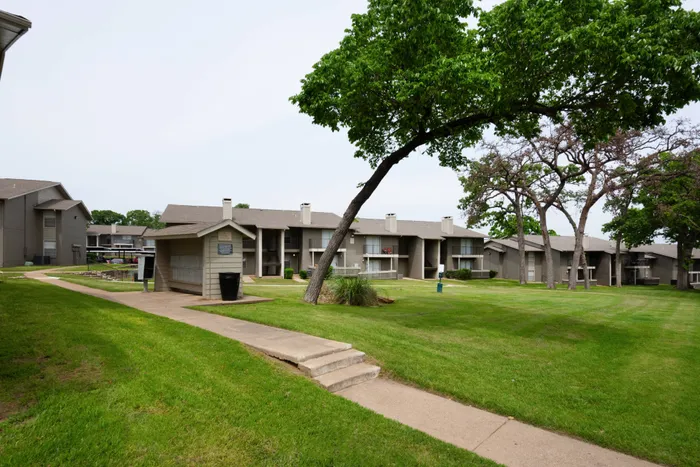 Beautifully landscaped courtyard at Oak Park Apartments in Euless, TX, with pathways and open green spaces.