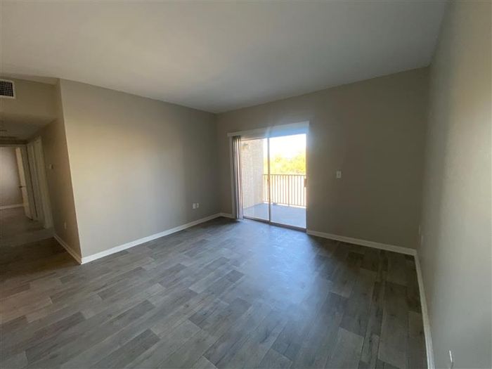 a living room with plenty of space and hardwood flooring