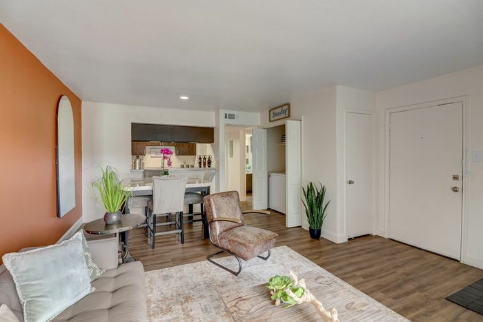 Open-concept living area at Oak Park Apartments in Euless, TX, featuring stylish decor, a dining space, and warm tones.