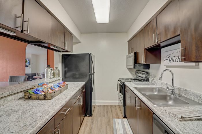 Modern kitchen with granite countertops and stainless steel appliances at Oak Park Apartments in Euless, TX.
