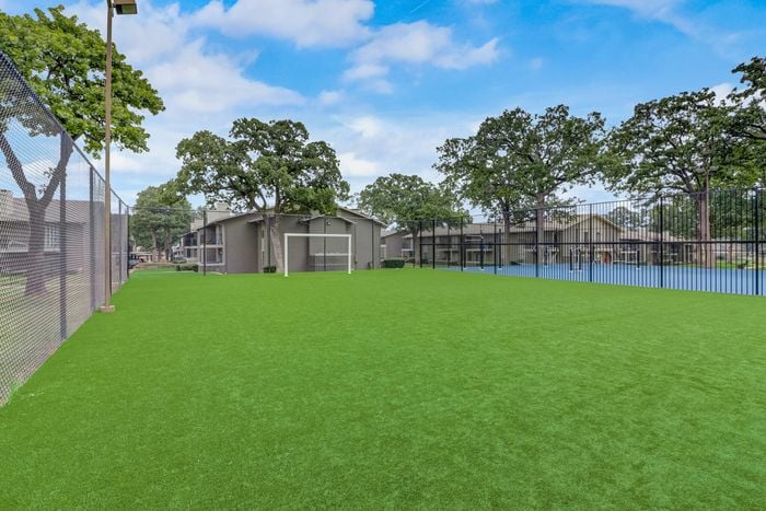 Outdoor recreation area with green fields and sports facilities at Oak Park Apartments in Euless, TX.
