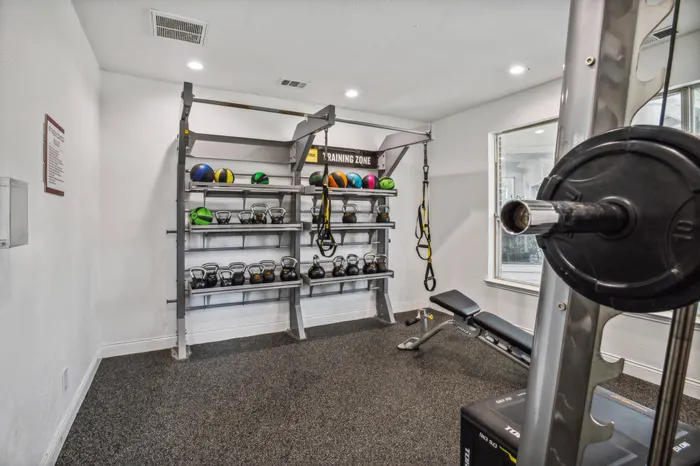 Modern fitness center with state-of-the-art equipment and natural light in a Plano, TX apartment community.