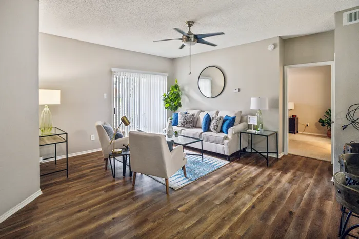 Stylishly furnished living room with wood-style flooring and natural light at a Plano, TX apartment.