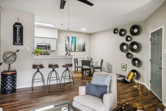 Stylish living with ceiling fan and open kitchen with breakfast bar
