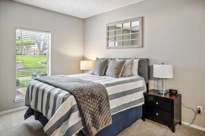 Cozy bedroom with natural light and modern decor at a Plano, TX apartment.