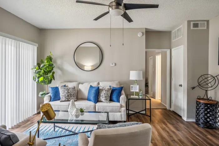 Stylishly furnished living room with wood-style flooring and natural light at a Plano, TX apartment.