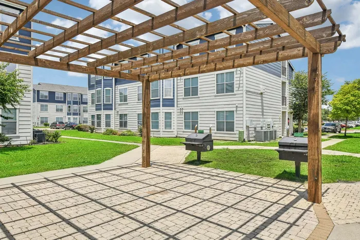 Family-friendly barbecue area with picnic tables and lush greenery at Towne West Apartments, Houston, TX